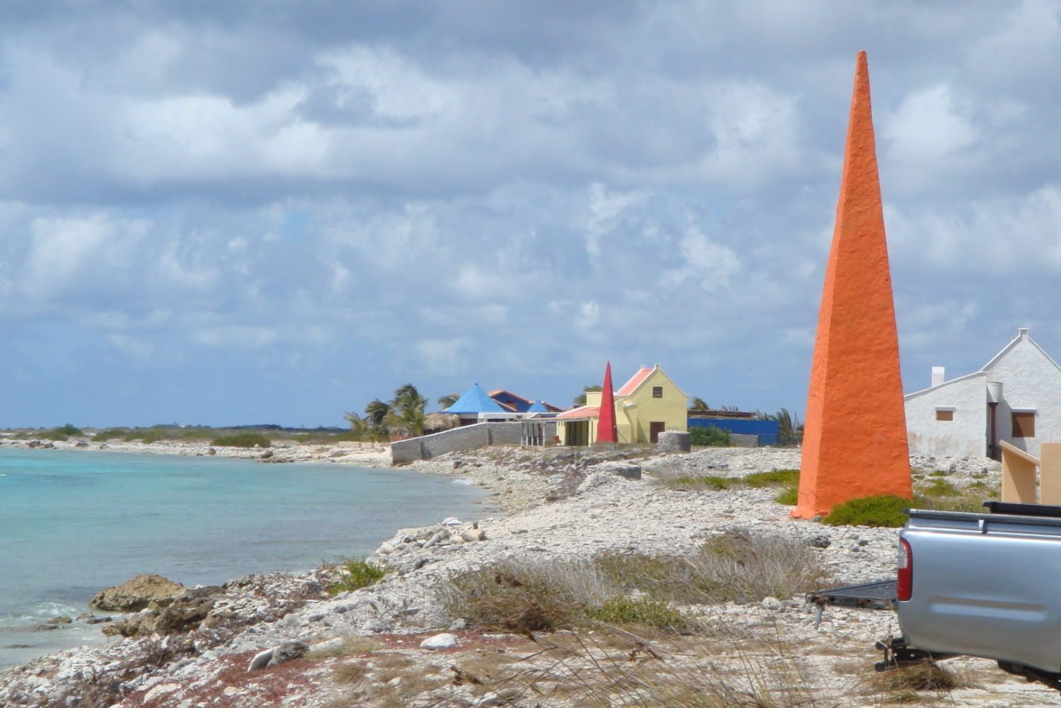 Coastal landscape with colorful buildings and obelisk.