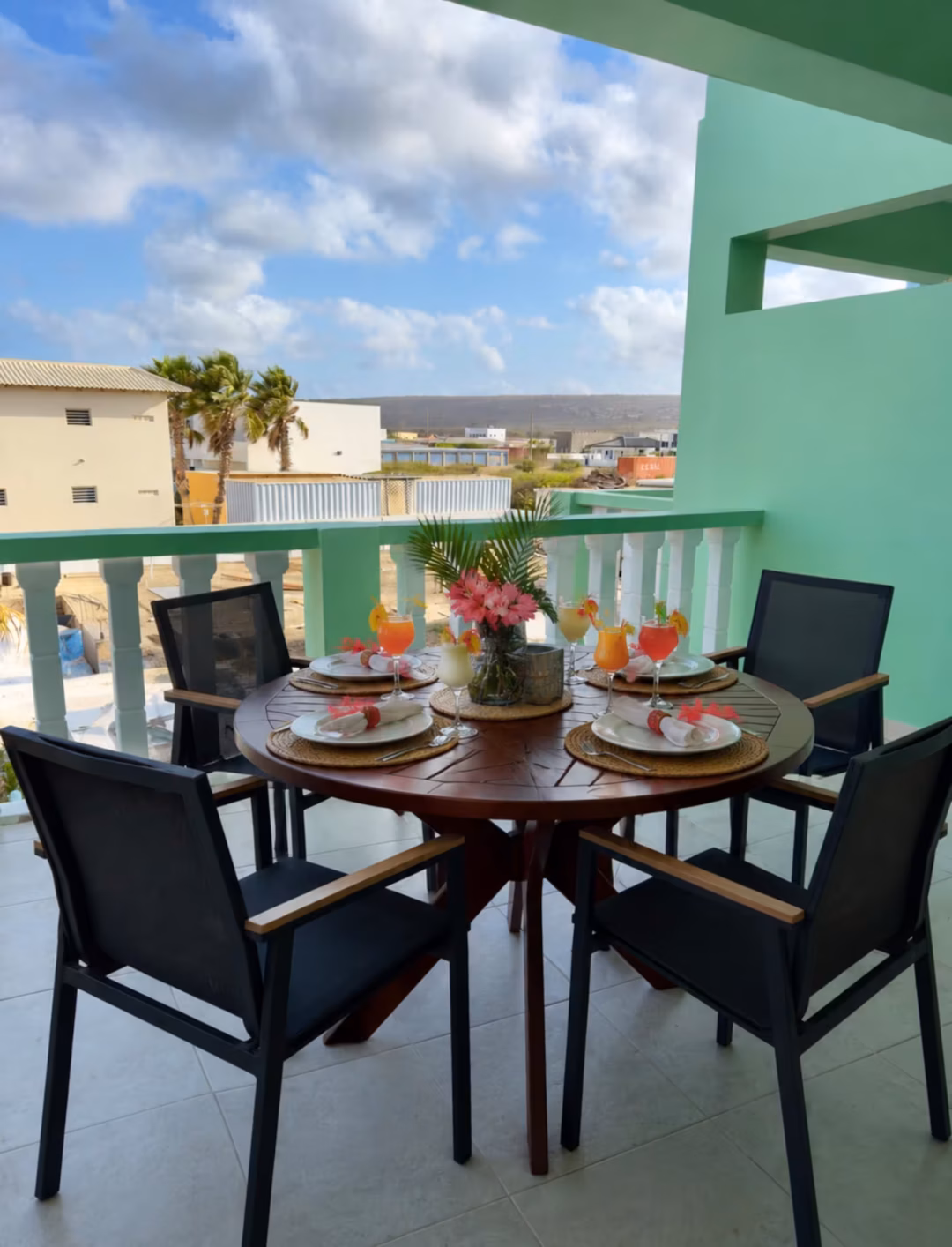 Outdoor dining table with drinks and flowers.