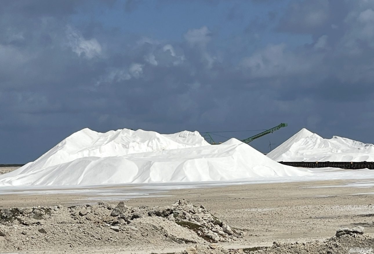 Salt piles under a cloudy sky.